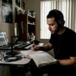 Rapper writing lyrics in home studio setting