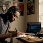 Hip-hop songwriter writing lyrics in home studio