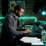 Rapper working at mixing console in studio