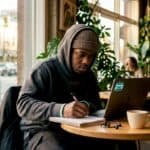 Rapper calculating streaming royalties at desk