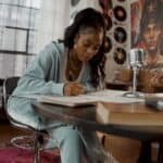 Songwriter working on lyrics at home studio desk