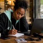 Music journalist writing notes in newsroom