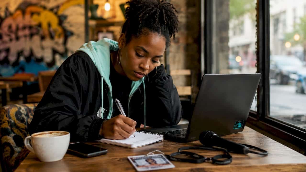 Music journalist writing notes in newsroom