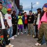 Group of diverse young people in vibrant hip-hop streetwear.
