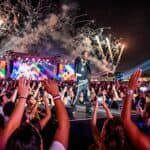 Stevie The Manager performing on stage at a large outdoor festival with fireworks.