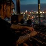 Hip-hop artist adjusting studio audio equipment