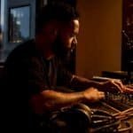 Producer hands adjusting synth loop in studio