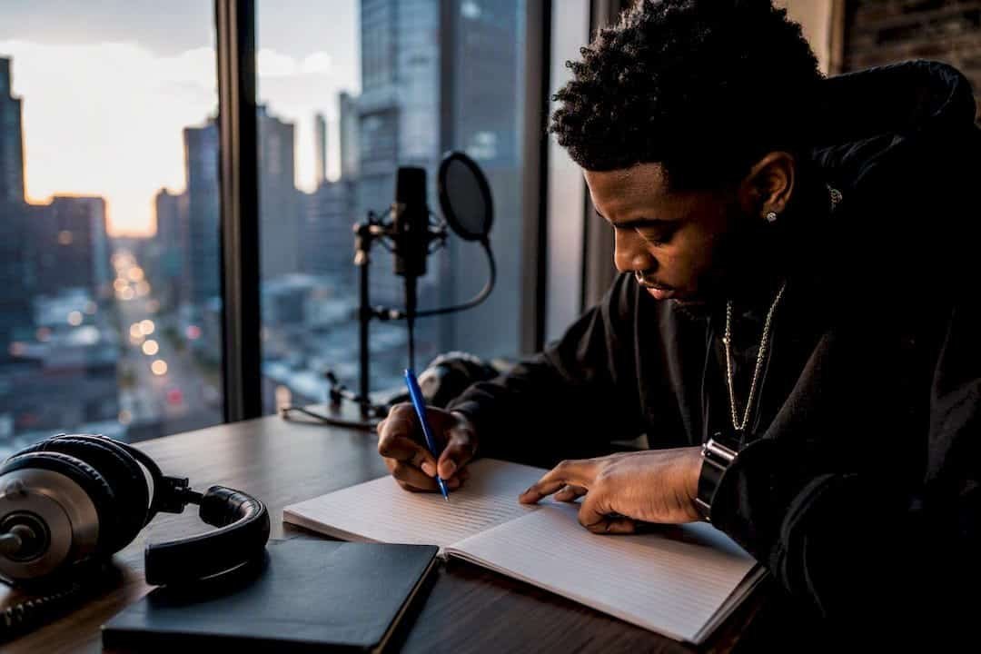 Hands writing rhyme schemes in studio