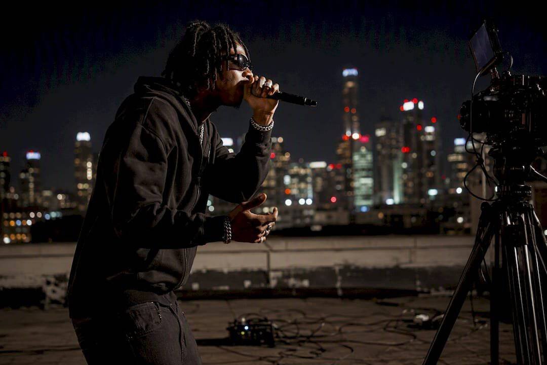 Hip hop artist performing cover video on rooftop