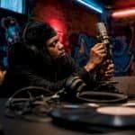 Artist tuning microphone in recording studio