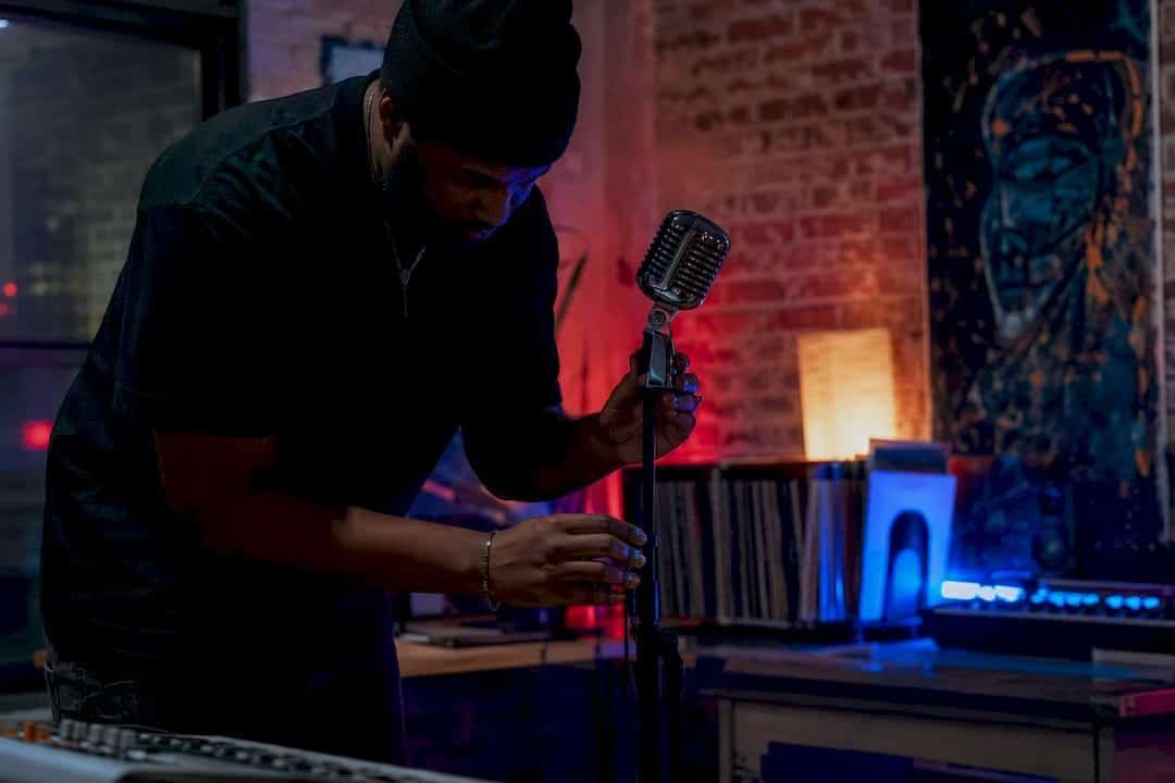 Hip-hop producer adjusting microphone in studio