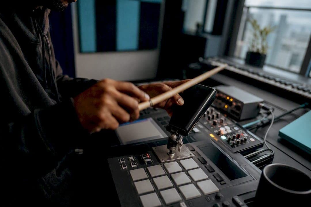 Hands hitting cowbell on drum machine