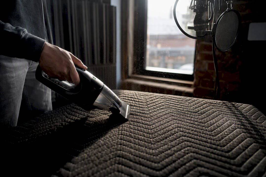 Vacuum cleaning moving blanket in vocal booth