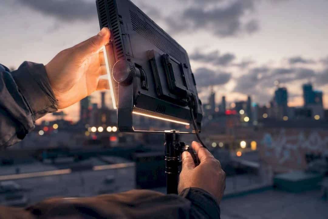 Hands adjusting camera and lighting gear