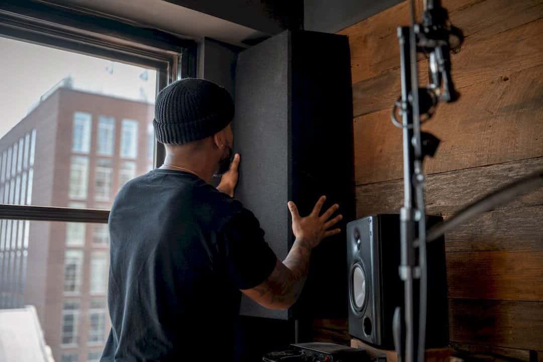 Hands installing corner bass trap panel