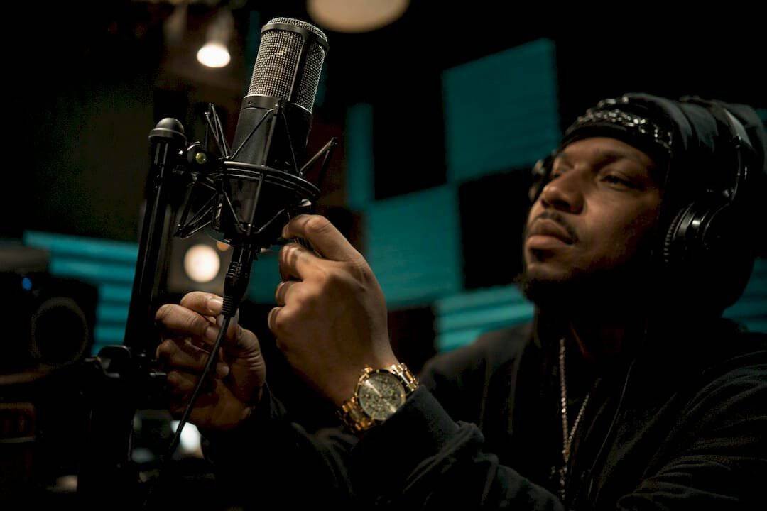 Artist adjusting microphone in home studio